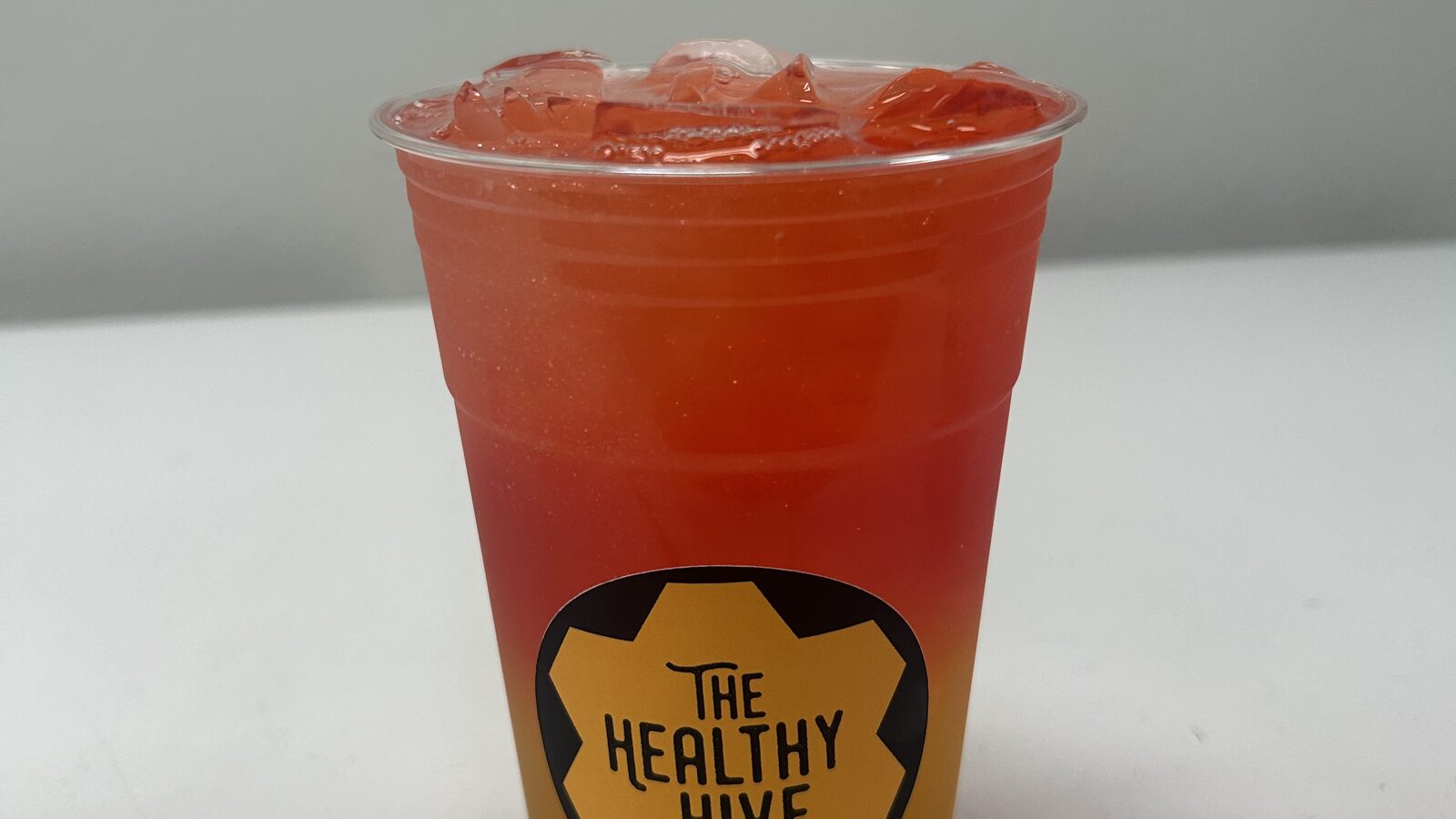 Red and orange iced tea in a Healthy Hive cup