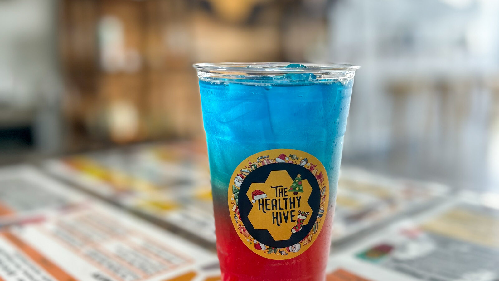 Holiday layered drink in a Healthy Hive cup on the shop counter